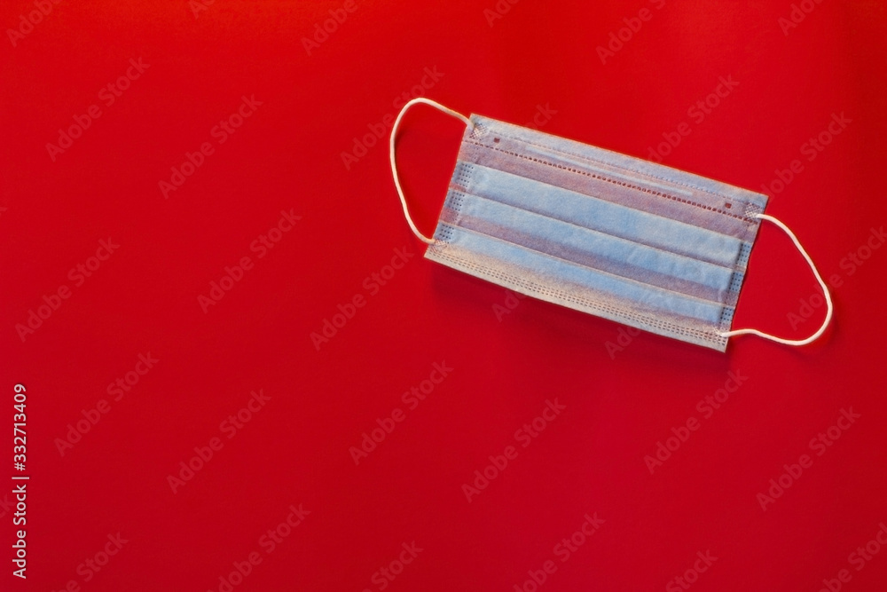 Medical fabric mask on a red background. Danger. Protection from coronavirus. Covid-19. Protection during the epidemic. Medical fabric mask on a red background. Danger. Protection from coronavirus. Covid-19. Protection during the epidemic.