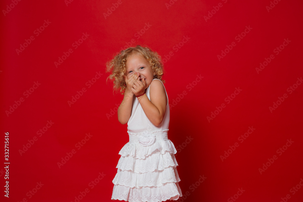 Pretty little blonde curly girl in white dress laughing isolated on red Pretty little blonde curly girl in white dress laughing isolated on red