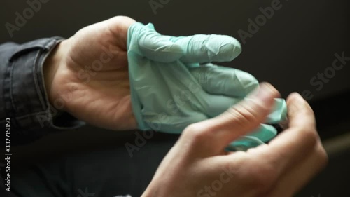 Person incorrectly removes protective medical gloves. Do not touch surface of the glove with   your bare hand. Personal hygiene for prevention epidemic. Disease outbreak, coronavirus   covid-19 pandem photo