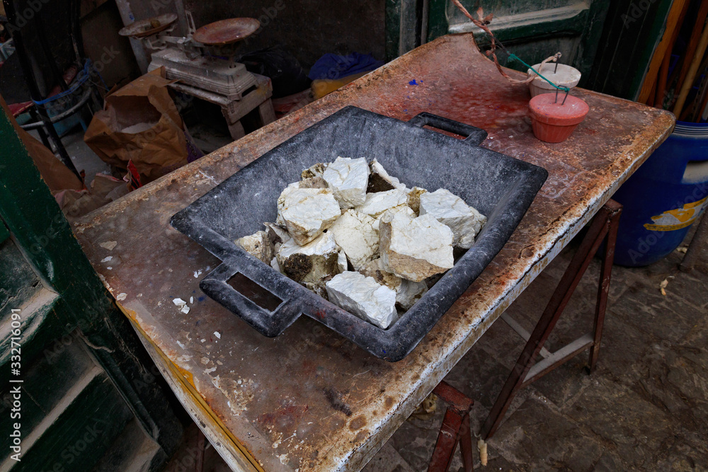 Large pieces of unknown material on an iron table in one of the stores in the old market of Tetouan Medina in Northern Morocco. Large pieces of unknown material on an iron table in one of the stores in the old market of Tetouan Medina in Northern Morocco.
