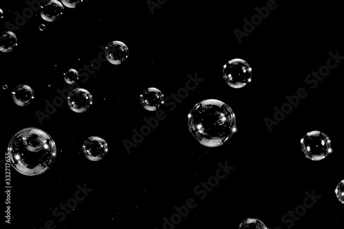 Flying soap bubbles isolated on a black background. Abstract background.