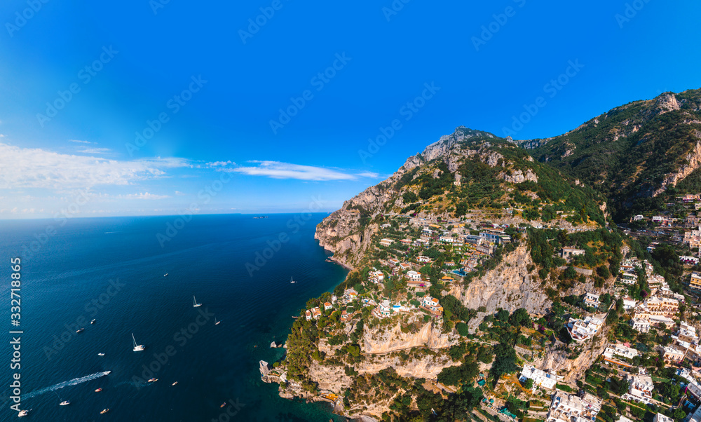 Beautiful aerial panorama view of Amalfi coast. Rocky shores and incredible beaches, Luxury yachts, boats and apartments overlooking Tyrrhenian Sea. Bright sunny day. Copy space. Positano, Italy