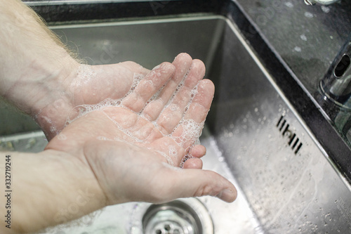 Hygiene concept. Washing hands with soap. Man soaps his hands to prevent virus