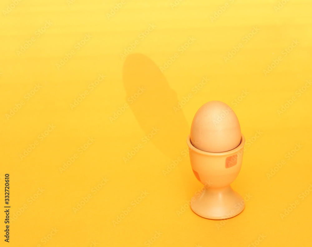egg in cup on yellow background egg in cup on yellow background