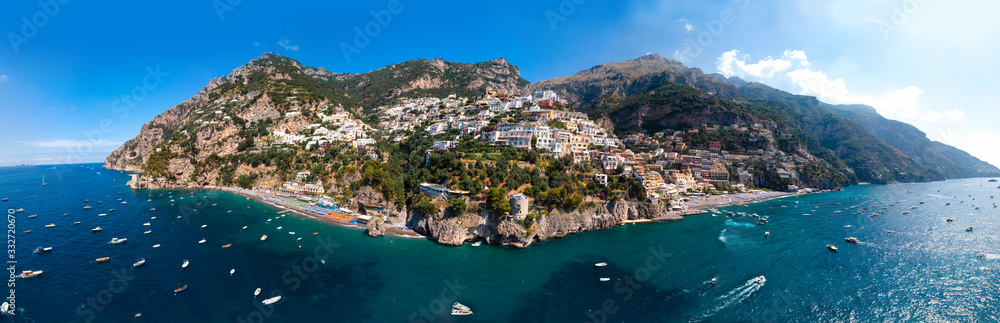Ultra wide aerial panorama view of Amalfi coast. Background. Rocky shores and incredible beaches, Luxury yachts, boats and apartments overlooking Tyrrhenian Sea. Bright sunny day. Positano, Italy