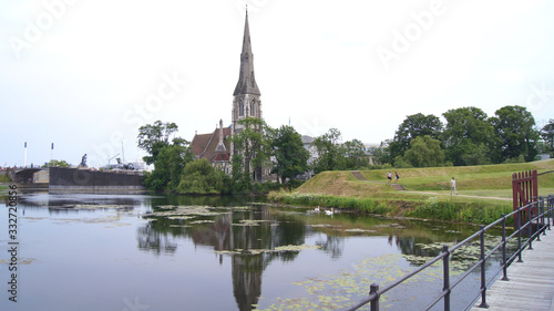 COPENHAGEN, DENMARK - JUL 04th, 2015: St Alban's Anglican Church and a reflection in the water during a sunset