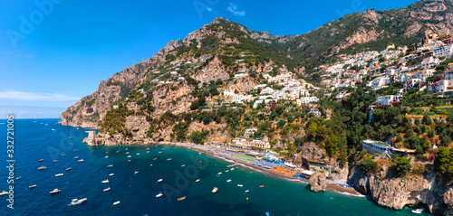 Beautiful aerial panorama view of Positano bay. Rocky shores and incredible beaches, Luxury yachts, boats and apartments overlooking Tyrrhenian Sea. Bright sunny day. Amalfitana, Italy