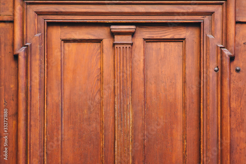 Antique luxury wooden door surrounded by handmade decor and carvings. Mahogany, portal to an ancient building.