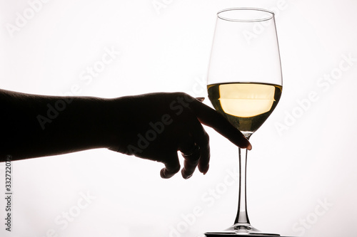 Female hand touching glass with white wine toasting isolated on a white background