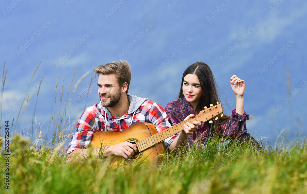 Romantic mood. Couple in love enjoying view from top of mountain. Boyfriend playing guitar. Singing for her. Romantic hike. Romantic couple on summer vacation. Idyllic place for romantic date