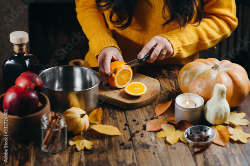 Cropped image of woman cutting fruits for mulled wine