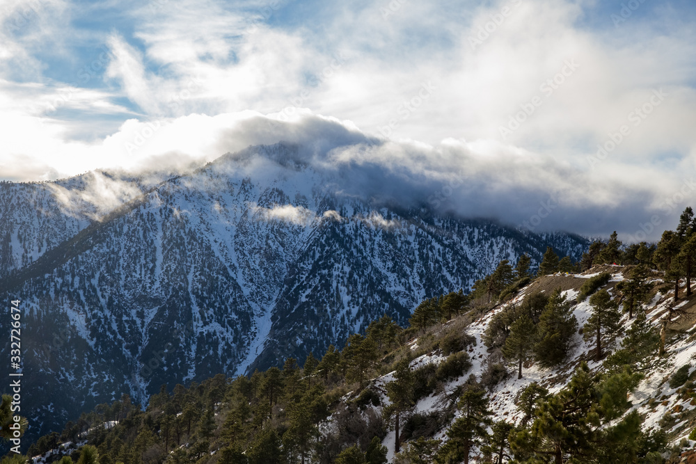 Fototapeta premium clouds covering snowy mountain top