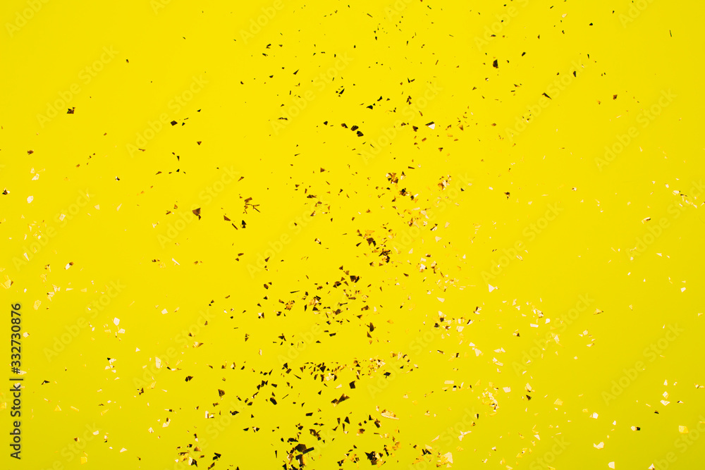 Golden flying sparkles on bright yellow background. Festive backdrop for your projects. Golden flying sparkles on bright yellow background. Festive backdrop for your projects.