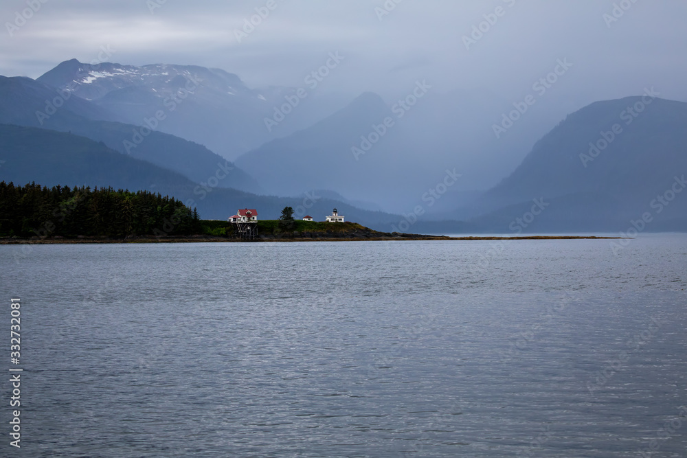Point Retreat Lighthouse, Juneau Alaska. Early on a foggy morning, snow on mountains in the background. 