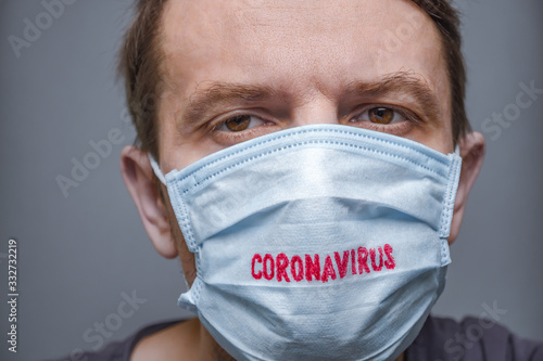 Coronavirus COVID-19. Pandemic background. Face of tired man in medical mask and gloves. Despaired male and new confirmed cases of coronavirus disease COVID-19. Negative emotions Facial expression photo