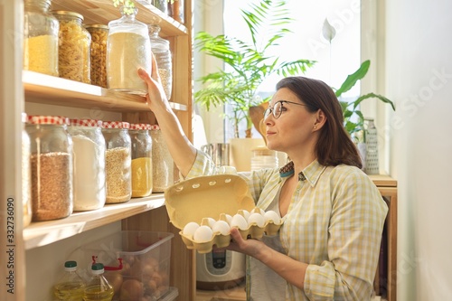 Woman in pantry taking products  eggs. Food storage  cooking at home