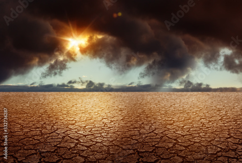 Cracked Soil - Global Warming Climate Changing Concept with Stormy Clouds on Background. Grunge Earth Backdrop.