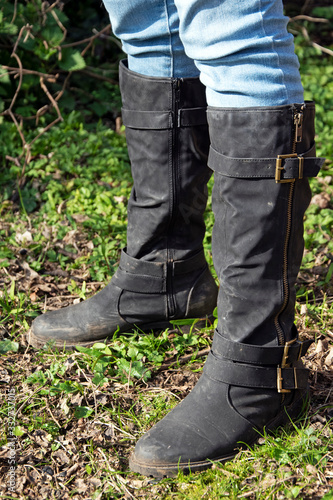Black boots and jeans on lawn