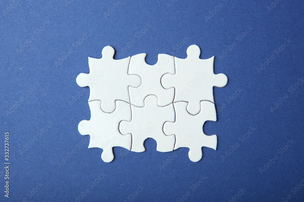 Obraz premium White puzzle on a colored background top view.