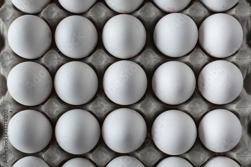 Full cardboard box of white chiken eggs close up. © alexburakov12