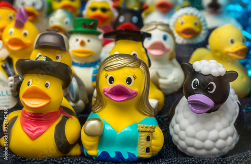 Collection of various rubber ducks in a shop window of a souvenir store.