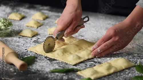 Woman making tasty ravioli on table, closeup