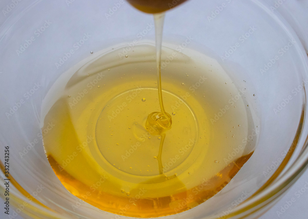 Honey dipper on the bee honeycomb background. Honey tidbit in glass jar and honeycombs wax Honey dipper on the bee honeycomb background. Honey tidbit in glass jar and honeycombs wax