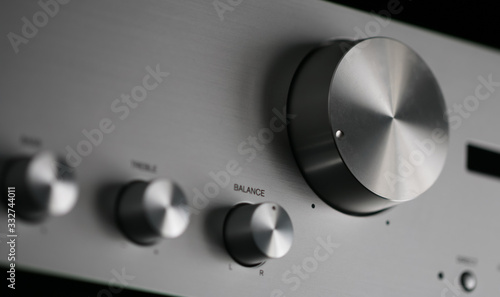 Close-up of Control Knobs on a Silver Metallic Amplifier