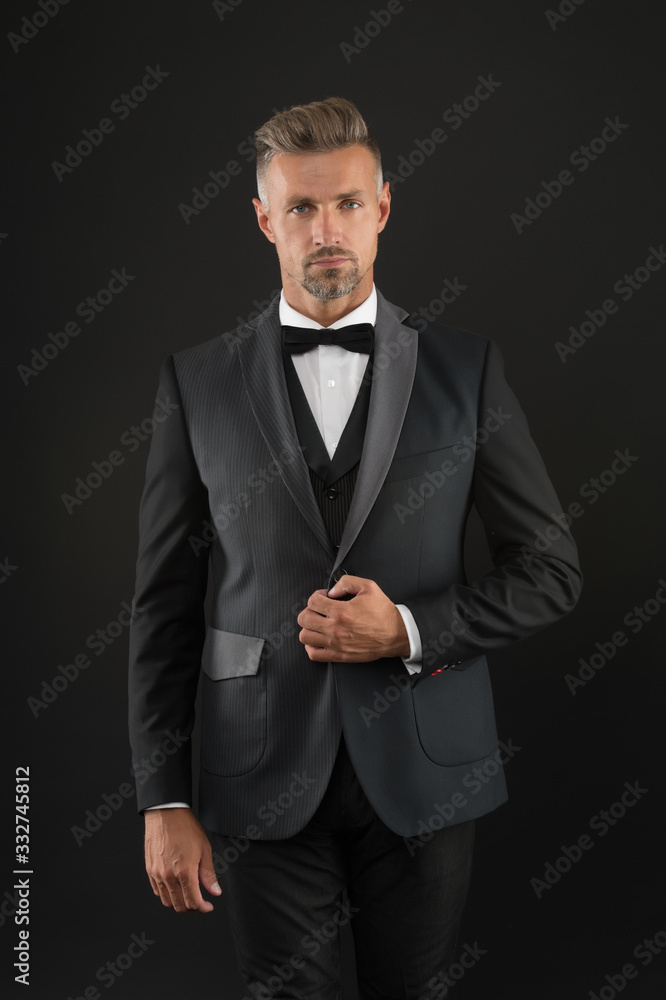 Appreciate classics. Bearded man with formal look. Hipster black background. Brutal man in tuxedo suit. Classic can make man look smarter. Black tie. Fashion shop. Buy clothes. Menswear concept Appreciate classics. Bearded man with formal look. Hipster black background. Brutal man in tuxedo suit. Classic can make man look smarter. Black tie. Fashion shop. Buy clothes. Menswear concept