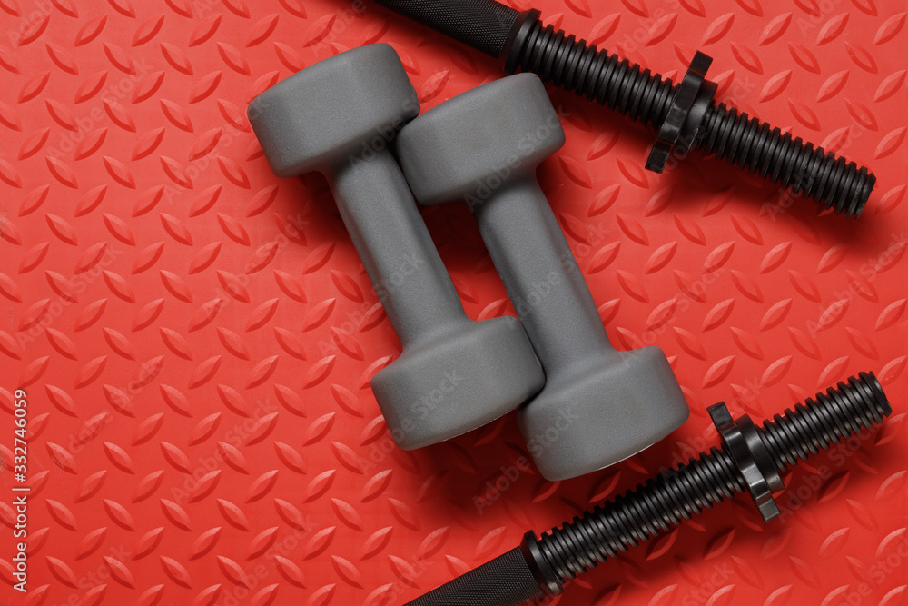 Fitness Gym Background. Fitness concept with Gym equipment on red background. Barbell and weights for workout Fitness Gym Background. Fitness concept with Gym equipment on red background. Barbell and weights for workout
