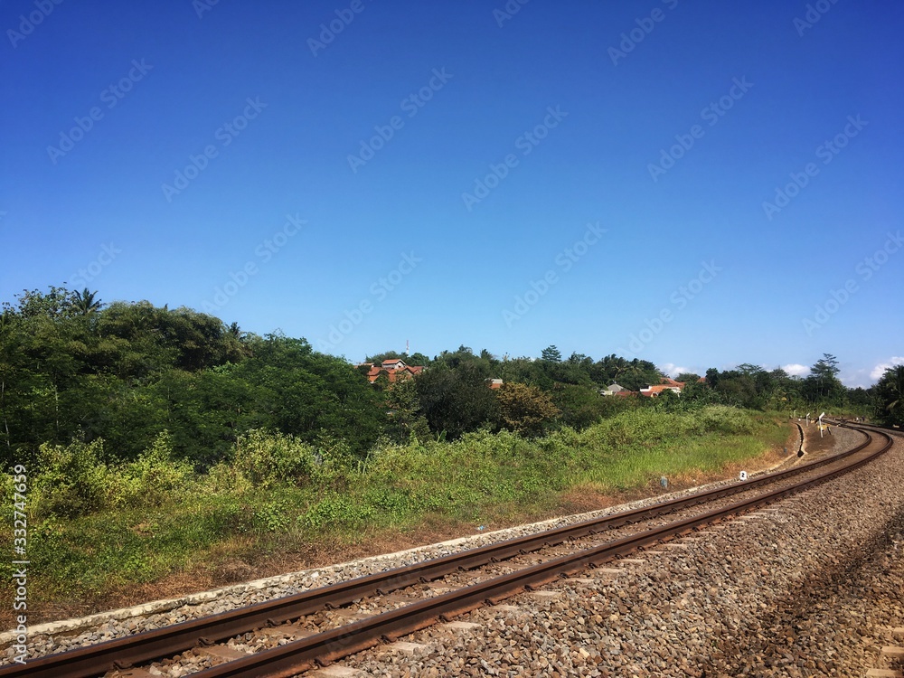 Obraz premium a railroad track ( rel kereta api ) in indonesia with a bush beside it
