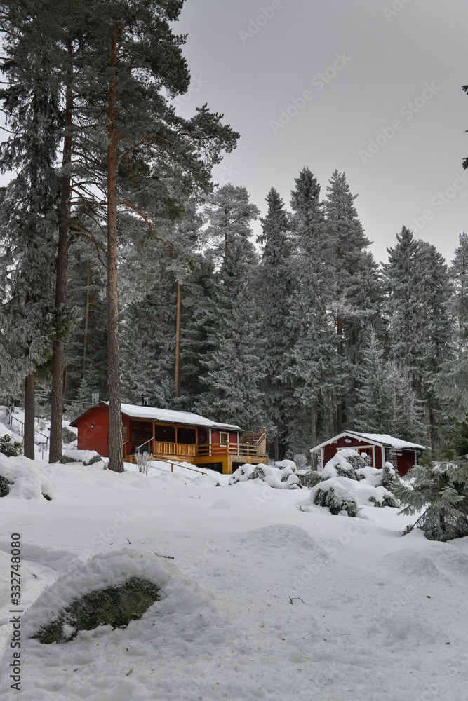 Petites cabanes rouge dans la forêt enneigée du nord arctique près de Luleå en Suède