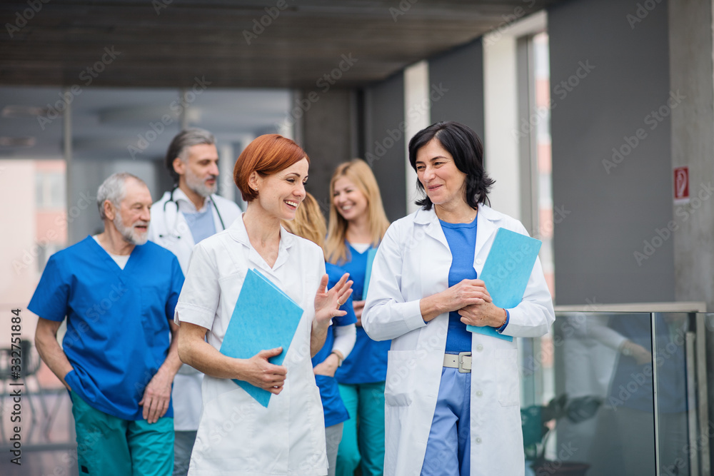 Group of doctors walking in corridor on medical conference. Group of doctors walking in corridor on medical conference.