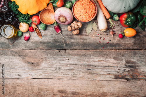 Fresh ingredients for healthy cooking or salad making on wooden background. Top view. Copy space. Diet or vegetarian food concept. Assortment of churd, pumpkin, carrot, pepper, cabbage, garlic photo