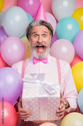 Vertical view portrait of his he nice attractive lucky cheerful cheery funky grey-haired mature man having fun celebrating great event Valentine day isolated over pink pastel color background