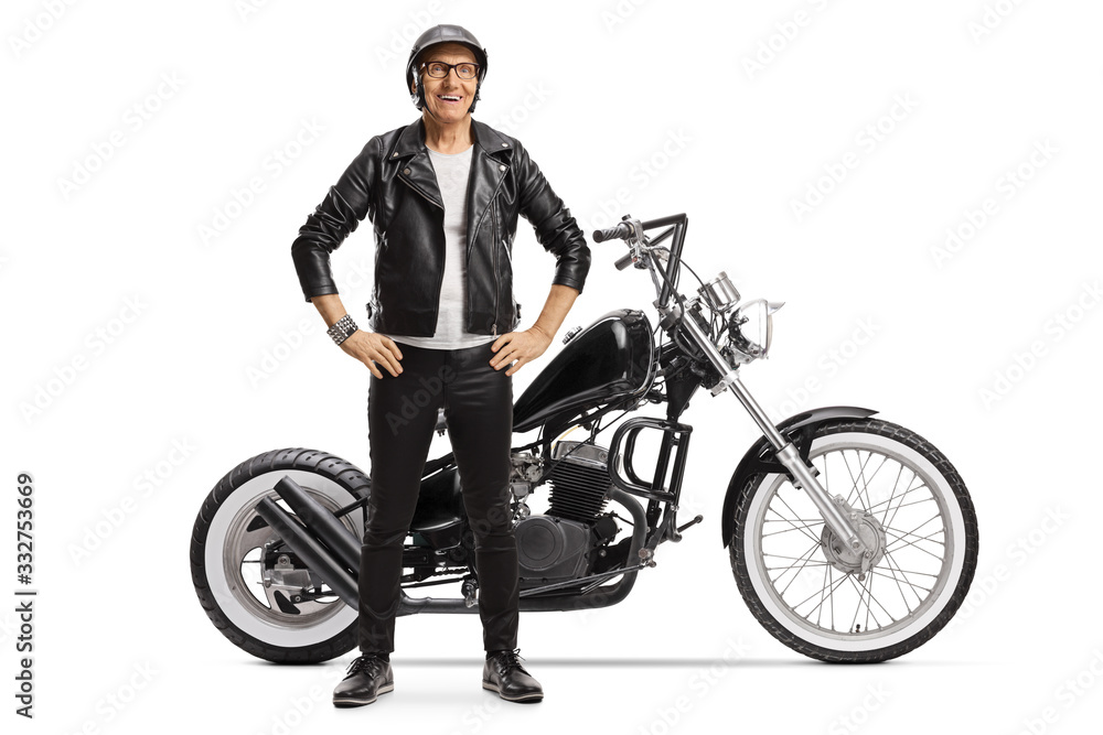 Naklejka premium Elderly male biker standing next to a custom motorbike