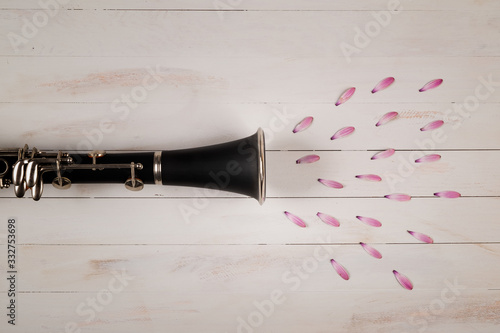 clarinet with petal flowers in wooden background