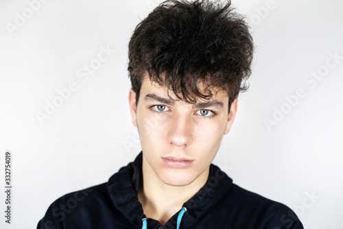 Cute teenage boy with serious face on light background. The guy is wearing a sports jacket and about to run in the stadium