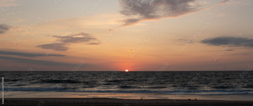 Fototapeta premium sunrise 1/2 way at the shoreline