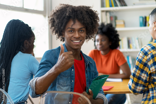 Successful african american male college student at desk at classroom