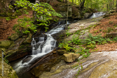 Mountainous green landscape of a river that crosses some rocks