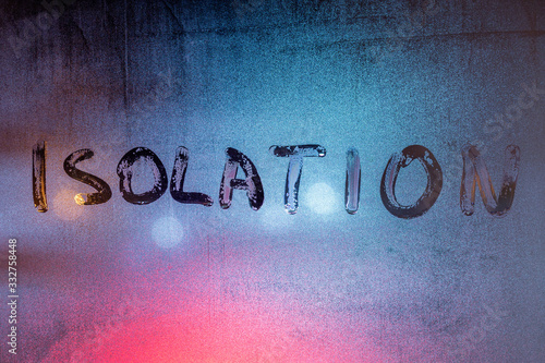 the word isolation handwritten on wet window glass at night - close-up full frame picture with selective focus