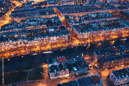 Amsterdam Netherlands aerial view at night. Old dancing houses, river Amstel, canals with bridges, old european city landscape from above. © DedMityay