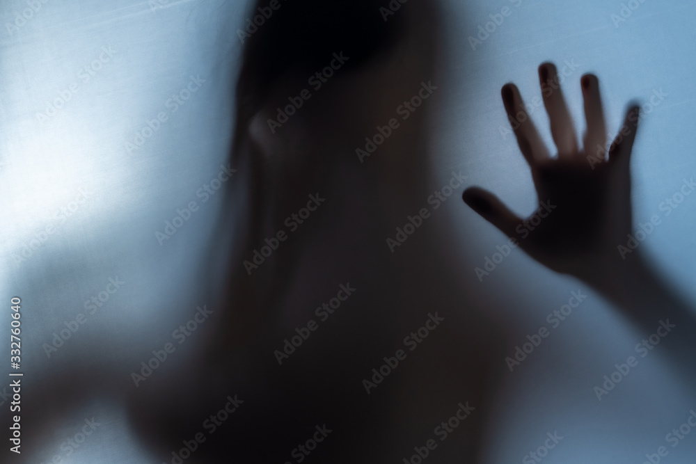 Blurred Woman's hand shadow asking for help. Horror and domestic violence concept