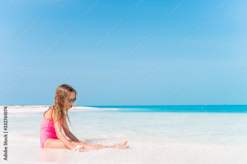Adorable little girl have fun at tropical beach during vacation Adorable little girl have fun at tropical beach during vacation