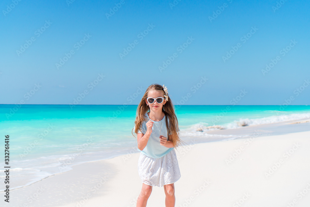 Adorable little girl have fun at tropical beach during vacation Adorable little girl have fun at tropical beach during vacation
