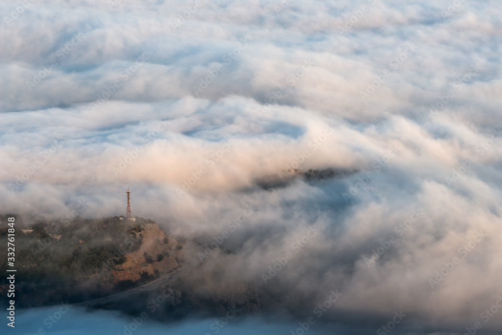 Communication tower over dense sea fog