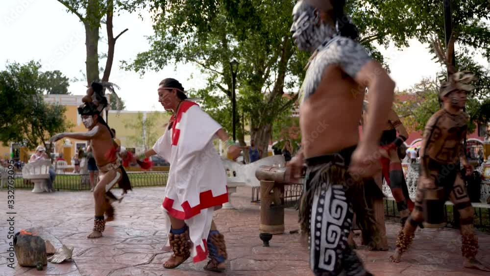 Mayan dancers performing to live drums, kicking legs into the air