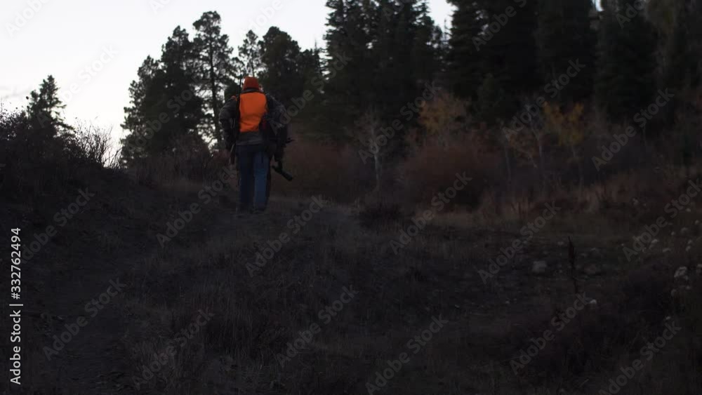 Father and Son Hunters walk up trail in early morning light. Handheld Slow Motion. 4K Father and Son Hunters walk up trail in early morning light. Handheld Slow Motion. 4K