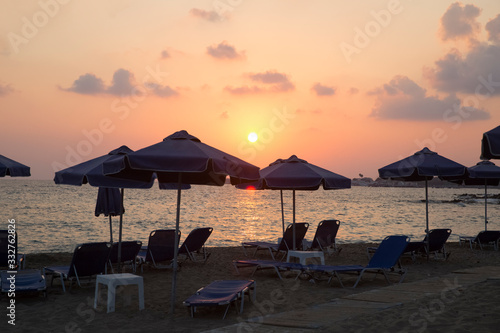 Sunset on the beach with umbrellas and sunbeds. There is nobody on the beach. SODAP Beach  Paphos  Cyprus